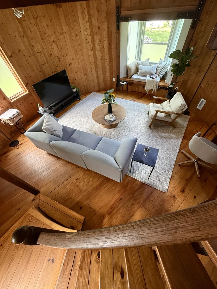 View from the loft down to the sofa, coffee table, and window seat.