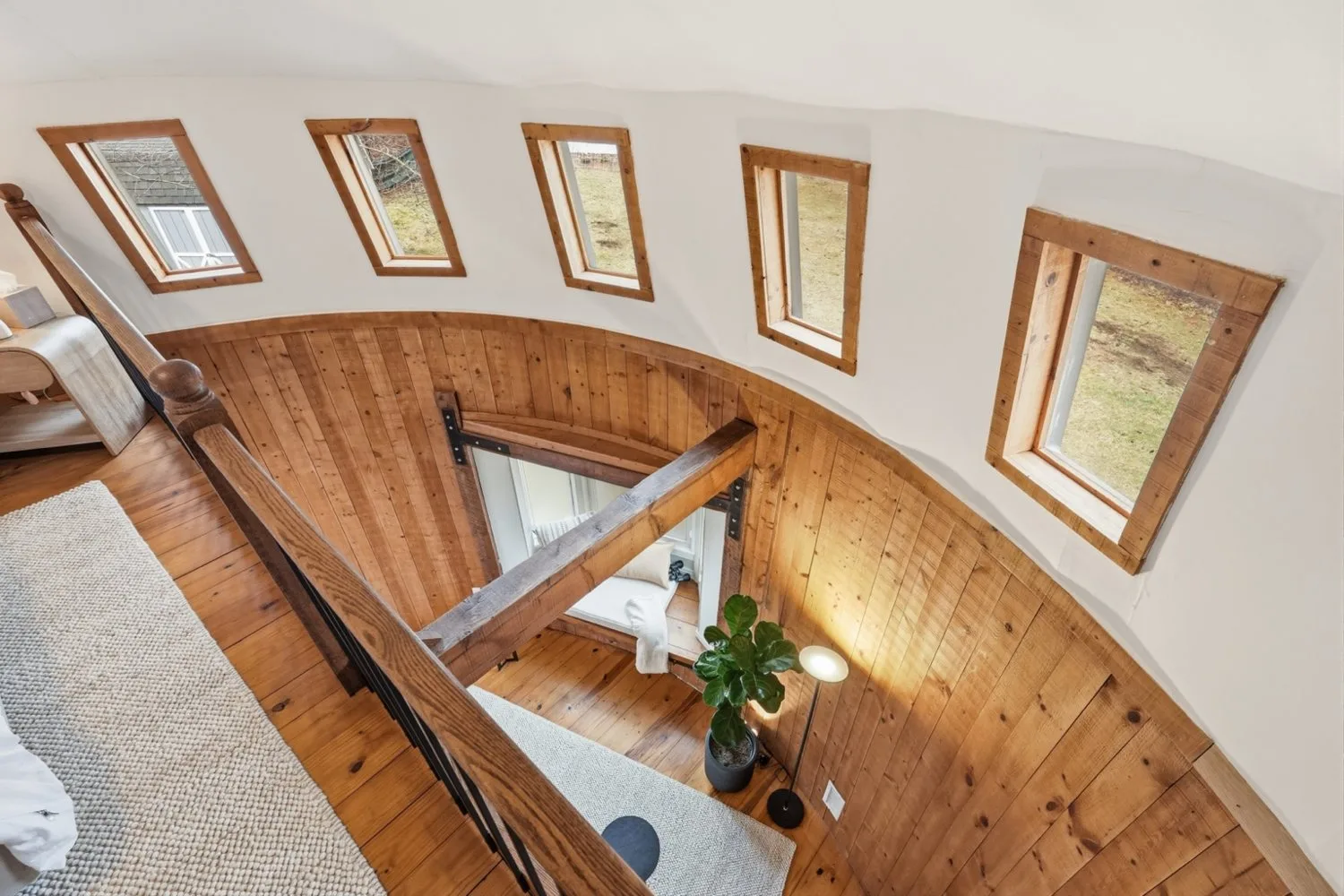 View from The Silo’s loft across the curved timber walls, tall windows and living area below.